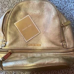 I am selling a Michael Kors gold backpack